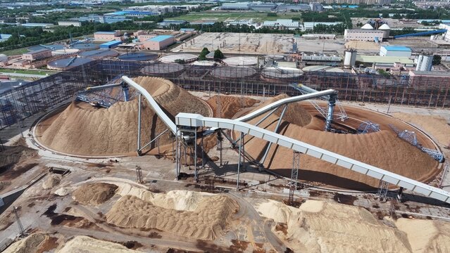 Industrial plant large material stockpile with conveyor belt system in operation
