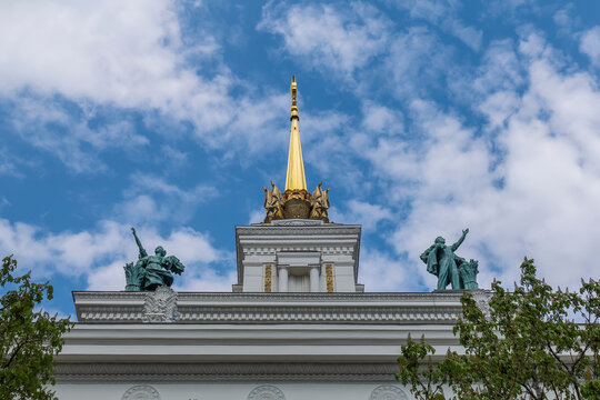 Soviet statues on the top of Pavilion No. 1 Tsentralny or Central in VDNH park, Moscow, Russia. Sunny spring day