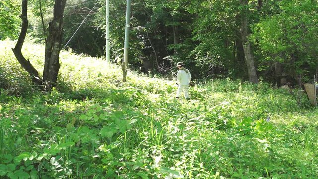 農業　芝刈り機で雑草を刈る日本人男性