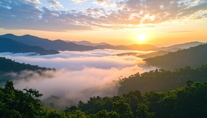Naklejka premium Breathtaking sunrise over misty mountains and lush green valley.