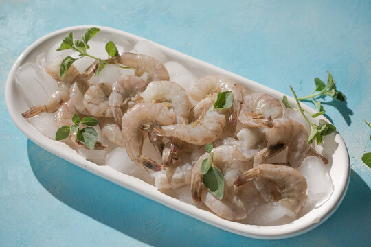 Raw pacific white shrimp prawn peeled with tail on ice.Top view. Copy space.