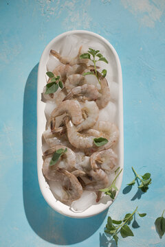 Raw pacific white shrimp prawn peeled with tail on ice.Top view. Copy space.