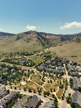 Aerial view of Fourmile Canyon Creek Trailhead with walking paths, green spaces, and residential homes nestled against the foothills of the Rocky Mountains, Boulder, Colorado, United States.