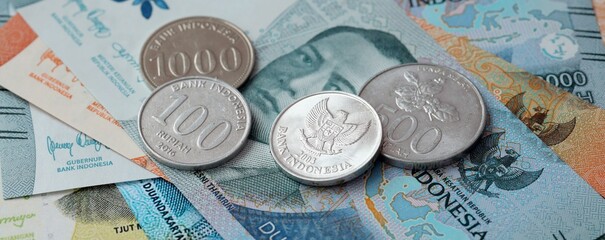 Indonesian rupiah money bills and coins on table. Indonesia cash of IDR currency © Larysa