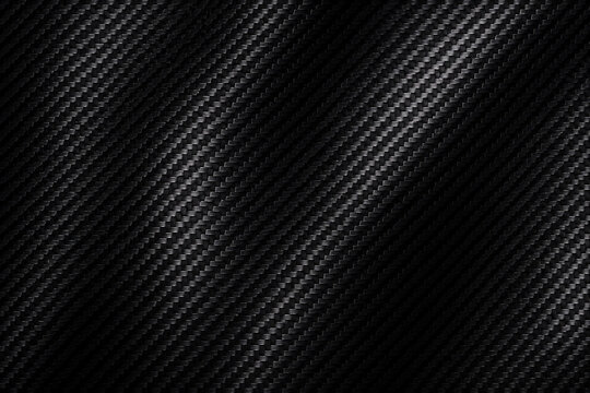 Black carbon fiber texture with diagonal woven pattern and dark metallic surface, sleek abstract background for automotive, technology, sports, luxury branding, web banners, and premium design.