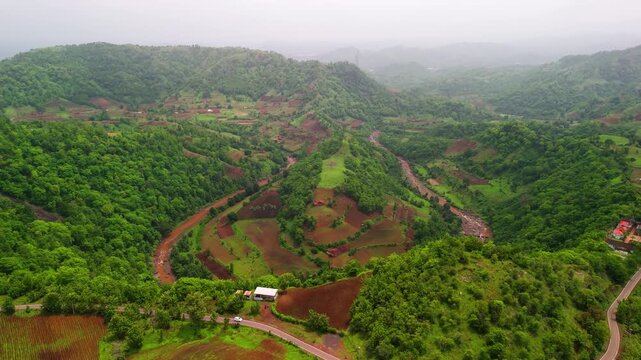Scenic Aerial View of Monsoon Hilly Jungle with U Shape River Flowing Through Dense Green Forest, Misty Mountains, Rainy Weather, Lush Vegetation, Natural Wilderness and Beautiful Tropical Landscape S