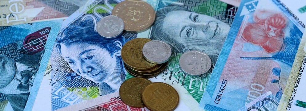 Peruvian sol money banknotes and coins on table. Peru cash bills of PEN currency