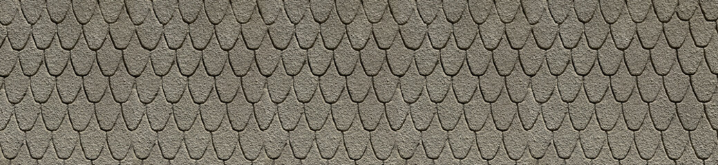 A panoramic view showcases a textured taupe stucco surface with dense fish scale shapes. The granular finish delivers a clean repeating masonry element for architecture headers. © EdisonArt