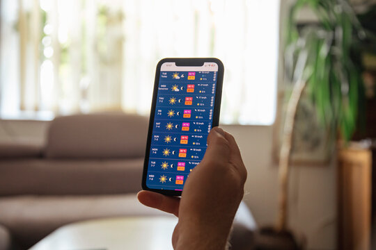 Person checking weather app. Summer heat wave concept, with over 30 degree