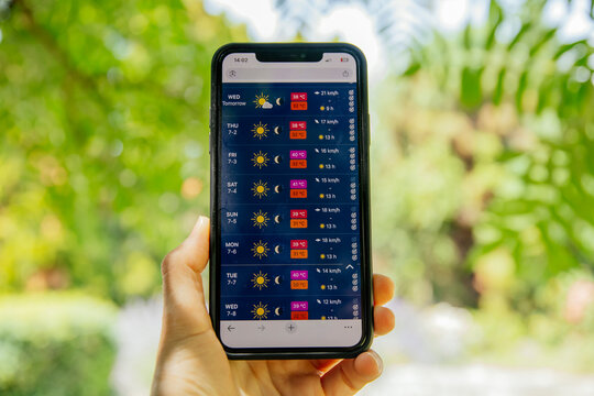 Person checking weather app. Summer heat wave concept, with over 30 degree