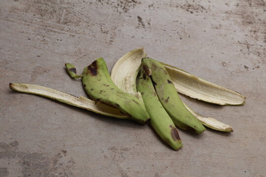Green Ambon banana peel resting naturally on earthy ground