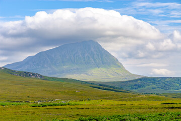Obraz premium View of Ben Hope with clouds drifting above, showcasing the stunning landscape of the Scottish Highlands and nearby lush meadows.