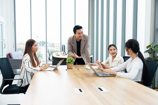 A group of professionals engage in a collaborative meeting in a modern office. The scene highlights teamwork, leadership, dynamic communication in a productive corporate environment.