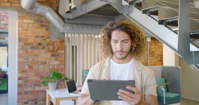 Diverse team watching man standing under stair reading tablet tapping screen smiling at content