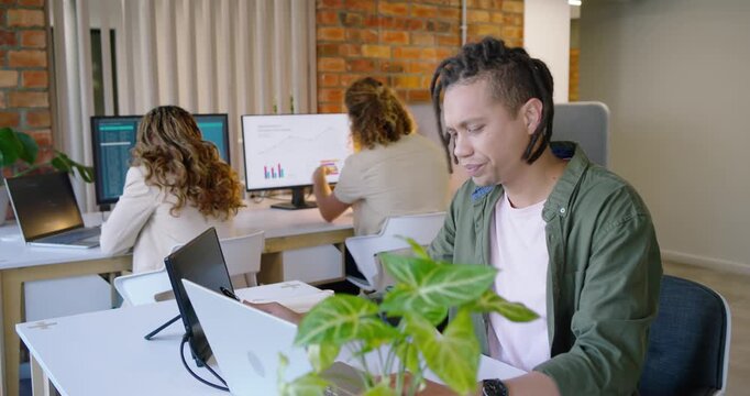 Team in open office male worker shifting reacting to colleague pointing at chart studying laptop