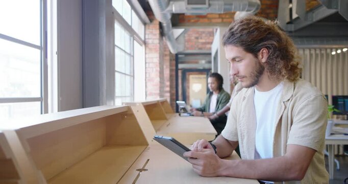 African men at counter, one opening tablet tapping stylus for work, other typing laptop, copy space