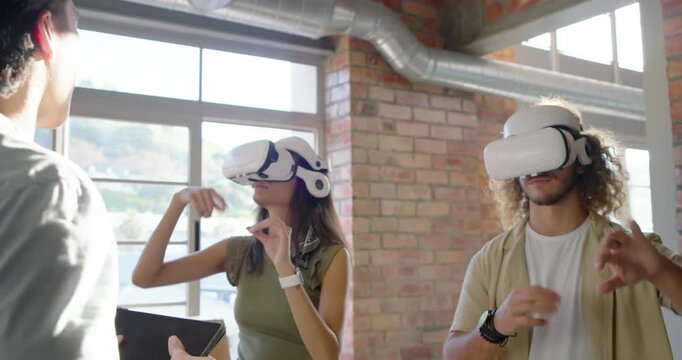 Diverse team briefing and exploring with white VR headsets, facilitator guiding on tablet in loft