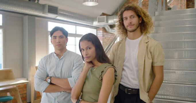 Diverse coworkers posing while camera recording adjusting smiling for team shot by window