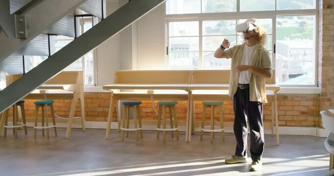 After headset powering on adult man standing in loft gesturing and exploring VR demo, copy space