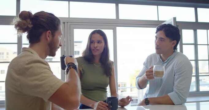 Three friends sitting at white counter, left man raising dark mug, catching up, smartphone visible