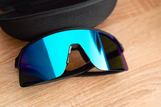 Blue-green mirrored polarised cycling sunglasses on a wooden table