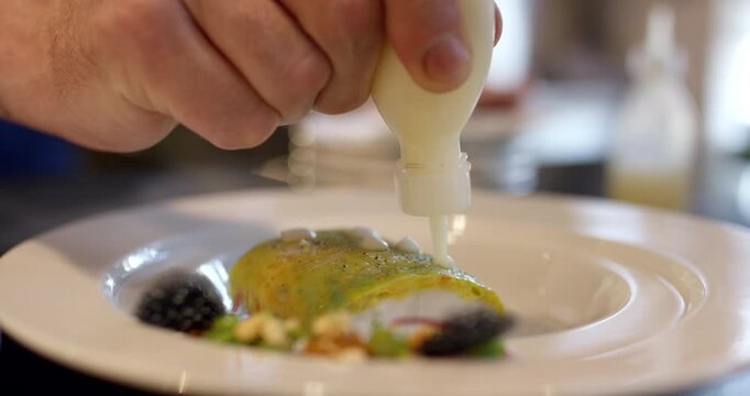 Overhead view of sliced chicken breast with microgreens on a white plate with cutlery