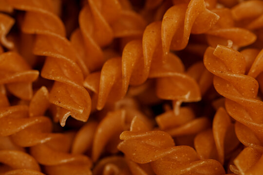 Detailed macro shot of uncooked whole wheat fusilli pasta spirals.