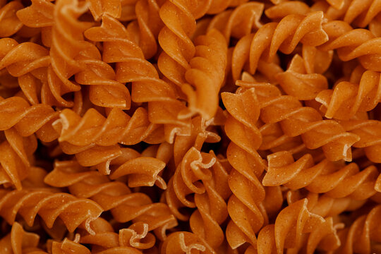 Close-up view of uncooked whole wheat fusilli pasta spirals, showcasing texture.