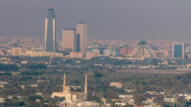 This drone timelapse taken above Deira Dubai demonstrates older traditional buildings and mosques situated near the historical creek. The low-rise urban fabric contrasts with distant modern towers.