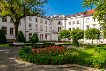 Fototapeta premium Historic buildings in old town of Göttingen in Lower Saxony, Germany. Sunny day in the public square park called “Wilhelmsplatz“ with the renovated facades of former university refectory or “Mensa“.