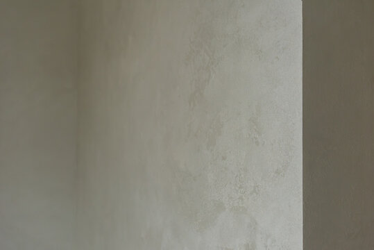 Smooth plaster wall painted in light gray color Neutral decorative plaster wall surface in interior corner showing modern renovation finish and soft texture
