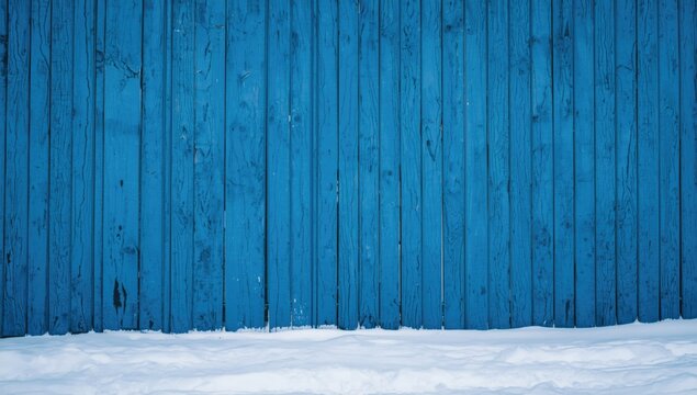 Blue wooden wall with snow at the base