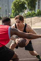 Obraz premium Two young men engaged in an exciting basketball match under the summer sun