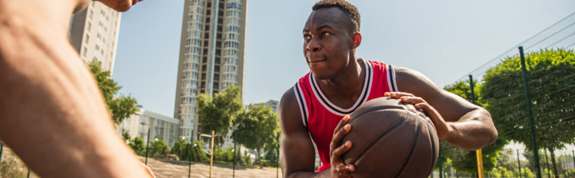 Young men enjoy summer street basketball on a vibrant outdoor court together