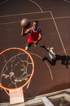 Young athletic man showcases skills on sunny outdoor basketball court