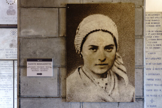 France. Hautes-Pyr&eacute;n&eacute;es. Lourdes. A photographic portrait of Saint Bernadette Soubirous adorns the hallway leading to the saint&rsquo;s relics in the crypt of the Shrine of Our Lady of Lourdes