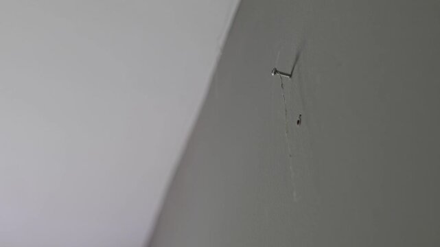 Hanging Thread from a strew on empty Wall