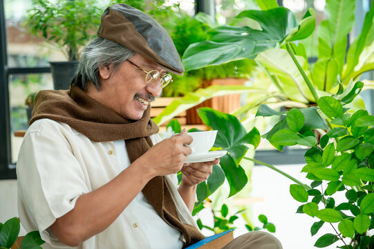 Senior man enjoying a cup of coffee surrounded by lush indoor plants creating a peaceful home atmosphere that represents relaxation wellness and healthy aging.

