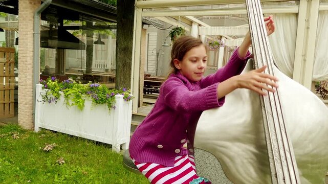 little girl depicts a double bass sculpture in Jurmala, Latvia.