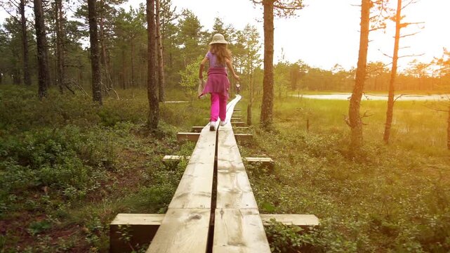 Little beautiful girl walks on swamp in Estonia
