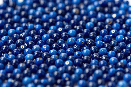 A close up of a bowl full of blue glass beads