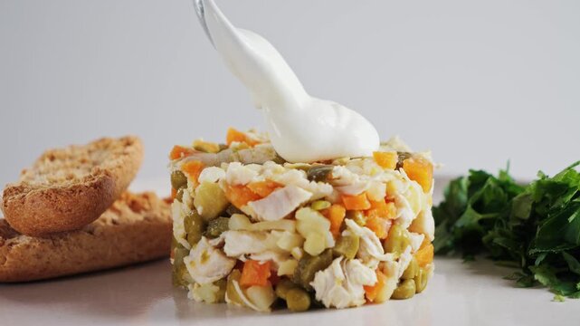 Salad with beef, boiled potatoes, vegetables, and canned peas dressed with a creamy sauce. Classic Olivier salad. High quality 4k footage