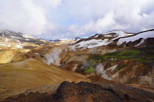 Aerial view of Kerlingarfjoll mountain range with geothermal steam vents, snow patches, and vibrant mossy slopes, Hella, Rangarthing ytra, Iceland.