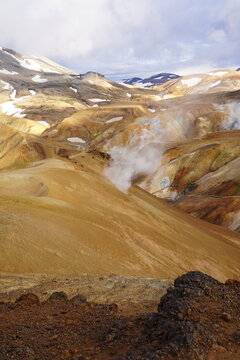 Aerial view of Kerlingarfjoll geothermal area with steaming vents, colorful rhyolite mountains, and patches of snow in Hella, Rangarthing ytra, Iceland.