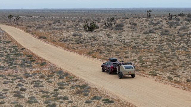 A sub pulls a teardrop camper trailer while exploring the desert landscapes of Baja California Mexico during a camping adventure.