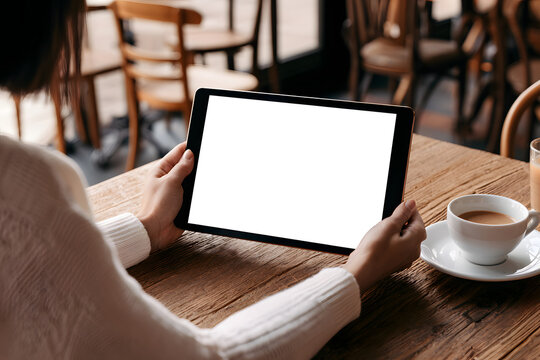 Mockup image of a woman holding a digital tablet on a caf&eacute; desktop screen