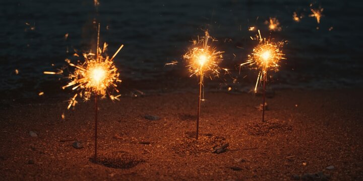 Sparklers burning on a sandy beach at night