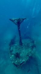 Sunken boat wreck with coral covered mast beneath the sea. Time and marine life have transformed abandoned sunken vessel into a haunting underwater scene for exploration and adventure. © Houston