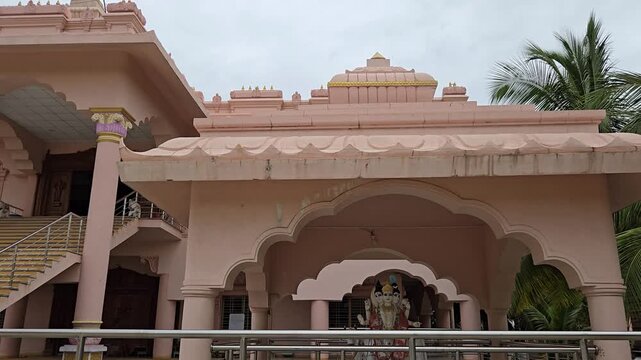 Shri Swami Samarth Ashram in Ganagapur, Karnataka, features a pink temple complex. Outside sits a beautiful Lord Dattatreya pavilion shrine. It provides critical seva and stay options for pilgrims.