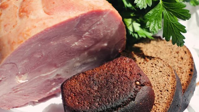 Farm ham close up with rye bread and parsley on wooden cutting board. Concept of healthy homemade breakfast. High quality 4k footage